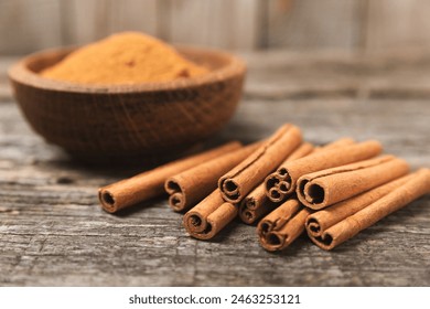 Cinnamon sticks on a textured wooden background. Cinnamon roll. Spicy spice for baking, desserts and drinks. Fragrant ground cinnamon. cinnamon powder Close-up. Place for text. copy space - Powered by Shutterstock