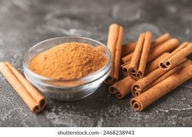 Cinnamon sticks on a textured wooden background. Cinnamon roll. Spicy spice for baking, desserts and drinks. Fragrant ground cinnamon. cinnamon powder Close-up. Place for text. copy space - Powered by Shutterstock