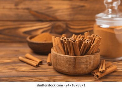 Cinnamon sticks on a textured wooden background. Cinnamon roll. Spicy spice for baking, desserts and drinks. Fragrant ground cinnamon. cinnamon powder Close-up. Place for text. copy space - Powered by Shutterstock