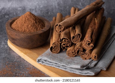Cinnamon sticks on a wooden background. Cinnamon spice in a spoon and bowl. Ceylon cinnamon. - Shutterstock ID 2180121165