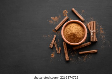 Cinnamon sticks and cinnamon powder on dark rustic background, healthy spice, (Cinnamomum) - Shutterstock ID 2263374723