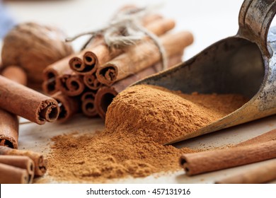 Cinnamon sticks and powder on a wooden table. Closeup view with details. Christmas holiday preparation - Powered by Shutterstock