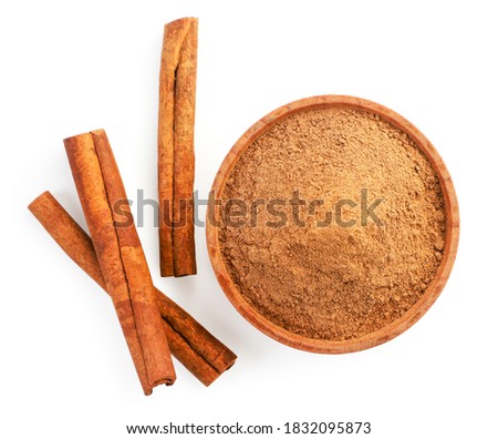 Cinnamon sticks and cinnamon powder in a plate on a white background, isolated. The view from top