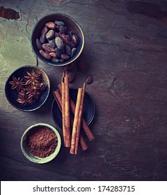 Cinnamon Sticks, Star Anise, Cocoa Beans And Cocoa Powder On Stone Background. Seen From Above. Flatlay. Copy Space. Natural Baking And Cooking. Natural Foods