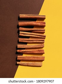 Cinnamon, Vertical Poster, Flat Lay. Concept Of Combination Of Two Flavors Of Vanilla, Chocolate. Vibrant Yellow, Brown Colors. Eco Spice. Cassia Tree Bark Texture Sticks On Double Diagonal Background