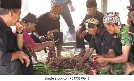 Ciptagelar, Indonesia - August 8 2019 : Asian Man In Black Clothes And Head Band Slaughter, Cutting Meat In Pieces And Share The Meat For Celebration At Seren Taun Harcest Festival