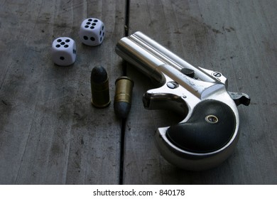 Circa 1889, Model 95, Type II Model 3 Double Derringer, on antique wooden table with shells and dice