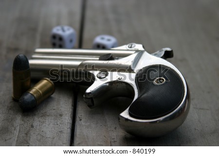 Circa 1889, Model 95, Type II Model 3 Double Derringer, on antique wooden table with shells and dice