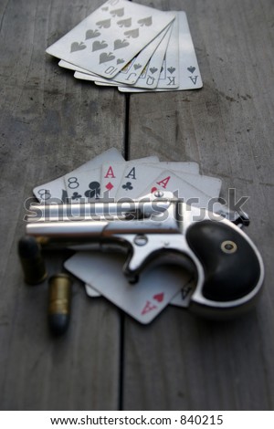 Circa 1889, Model 95, Type II Model 3 Double Derringer, on an antique wooden table with aces and eights aka a 