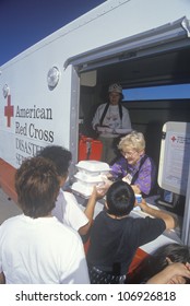 CIRCA 1994 - A Red Cross Worker Handing Out Meals From A Disaster Services Van