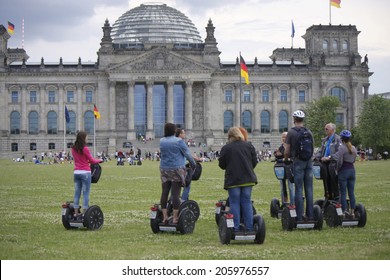CIRCA JUNE 2014 - BERLIN: a group of tourists on Segways at the lawn before the Reichstags building in the Tiergarten district of Berlin.