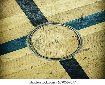 Circle Cover For Training Equipment In Floor Of School Gym. Painted Lines On Wooden Floor Of Sporting Hall With Sratched Surface. 