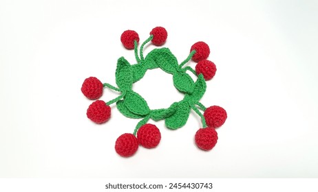 Circle pattern of cherry fruit amigurumi on white background.