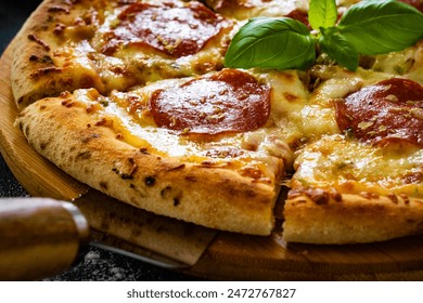 Circle pepperoni pizza with mozzarella cheese on black wooden table - Powered by Shutterstock