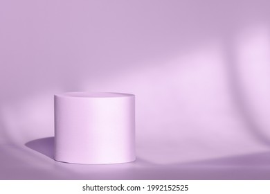 Circle platform stage for cosmetic products with geometric shadow on wall. Purple round pedestal podium for packaging presentation on backdrop with room shadows from window. Minimalist style