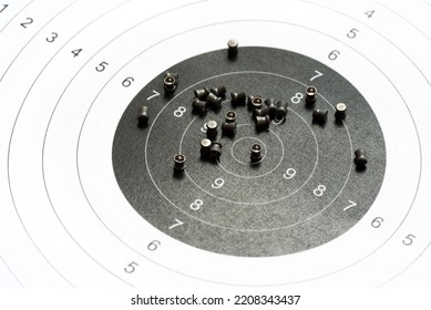 Circle Shooting Target And Lots Of Metal Pellets Laying On Top, Object Closeup, Detail, Nobody. Airgun Sports, Accessories. Pellet Ammo, Air Guns Ammunition, Range Aim Training Concept, No People