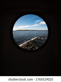Circle Window View Looking Outside of a Ferry Boat of a the Blue Waves on the Lake while Traveling