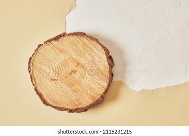 circle wooden platform on beige background of beige torn paper and texture, Empty showcase for presentation of cosmetic products, pedestal, mock up, copy space