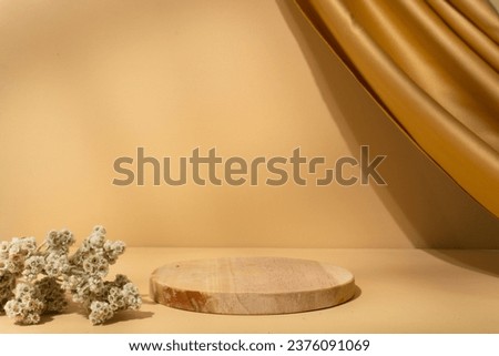 Circle wooden product placement podium with dried plant, aesthetic hanging brown fabric curtain and window shadow on golden luxury background