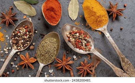 A circle of wooden spoons holding an array of assorted spices rests on a rustic stone tabletop. This vibrant display resembles an exotic Oriental spice market, brimming with colorful herbs and season. - Powered by Shutterstock