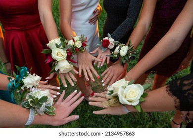 A circle of wrist corsages before a school prom dance. Beautiful group of girls wearing traditional flowers at the homecoming dance	