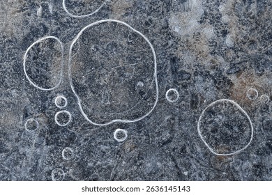 Circular air bubbles trapped in frozen surface captured from above in a macro view, revealing natural winter patterns in ice. - Powered by Shutterstock - Get 15% off with code: PIKWIZARD15