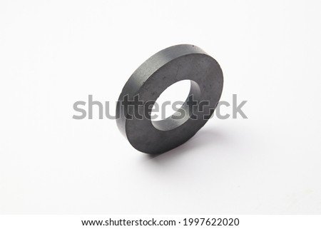 Circular black ferrite ring magnet isolated on a white background
