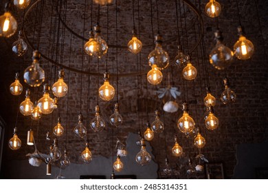 A circular chandelier of vintage light bulbs hangs from a brick ceiling, casting a warm glow in a Moscow cafe or home. - Powered by Shutterstock