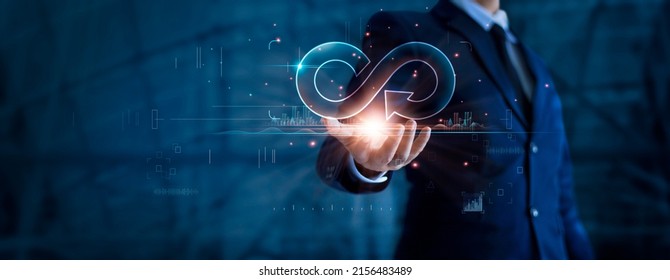 Circular economy and infinite. Businessman holding circular infinity colorful symbol on dark blue, Strategy of investment, Banking and financial, Development and data exchange for business growth.