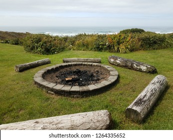 Circular Fire Pit With Charcoal And Logs At Beach