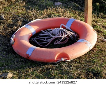 circular lifebuoy on the ground, fallen on the gorund after storm in the coast. Safety equipment near the ocean.