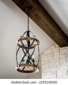 Circular Light Fixture Hanging From A Wooden Beam