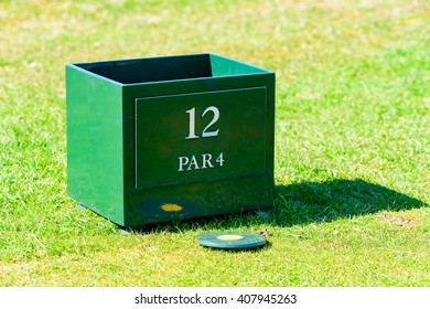 Circular Marker Lying On Tee On A Golf Course. Nicely Cut Grass Surround It. Peg Box For Broken Pegs On Hole 12, A Par 4 Hole.