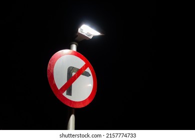 Circular No Right Turn Traffic Sign Illuminated At Night Against A Dark Sky