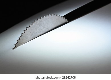 Circular Saw Cutting White Paper Sheet On Dark Background