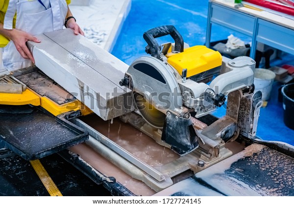 Circular saw in production. Sawing a concrete slab.\
Cut a stone plate with a circular saw. Stationary circular saw.\
Mason. Stone processing. Stone production. Build. Work on a\
construction site.