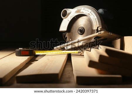 Circular saw and wooden boards close up background. Front view. Woodwork.