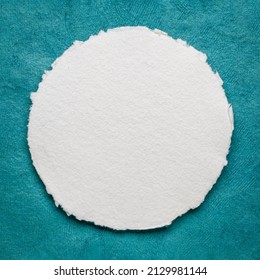 circular sheet of blank white watercolor paper against turquoise handmade bark paper - Shutterstock ID 2129981144