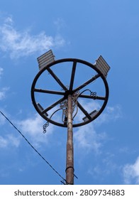 Circular Stadium Floodlight Pole Against Blue Sky