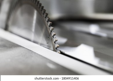 Circular table saw disc with carbide teeth, close-up photo with selective focus