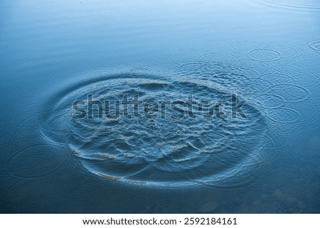 Circular water ripples and bubbles effect. Water ripples and round droplets on blue sea texture pattern background. Liquid motion on calm lake surface. Ring affect, circles