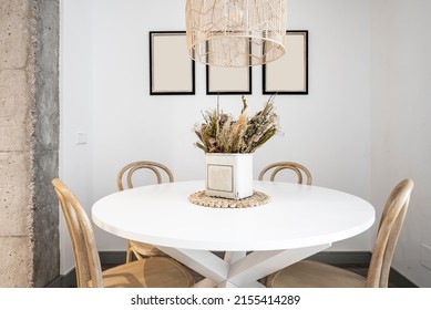 Circular White Wooden Dining Table With Wooden Chairs Decorative Centerpiece And Concrete Pillar