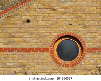 Circular window in old brick wall.