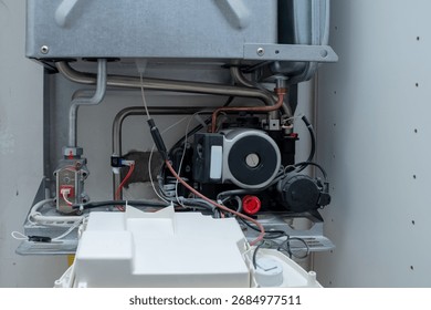 Circulating Pump and Copper Pipes within a Domestic Gas Boiler, Exposed Plumbing and Electrical Wiring for Heating System Service, HVAC Maintenance and Repair Detail Shot