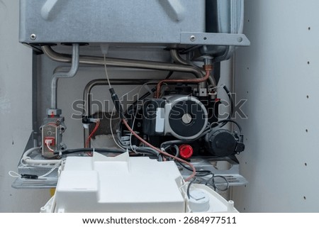 Circulating Pump and Copper Pipes within a Domestic Gas Boiler, Exposed Plumbing and Electrical Wiring for Heating System Service, HVAC Maintenance and Repair Detail Shot