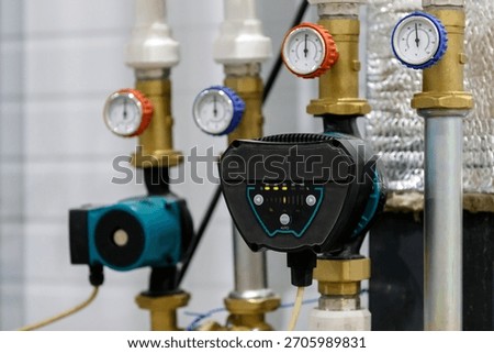 A circulation pump with thermometers is installed in a heating or water supply system