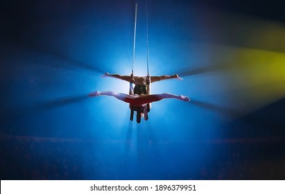 Circus actress acrobat performance. Two boys perform acrobatic elements in the air