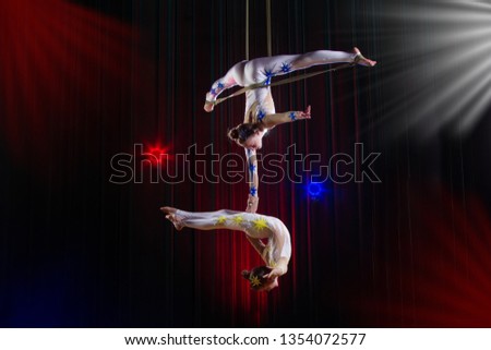 Circus actress acrobat performance. Two girls perform acrobatic elements in the air.