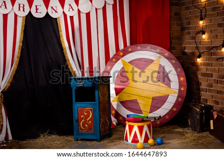 Circus backstage in retro style, drum on aa pedestal. Red stripped curtain background with various circus objects. Circus Theater stage. Old circus arena interior