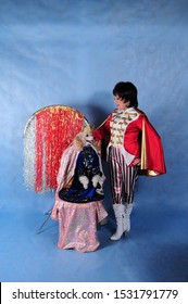 A circus dog dressed as a king with a crown in the Studio on a blue background on October 3, 2014. The trainer in a beautiful suit in the Studio with a smartly dressed dog